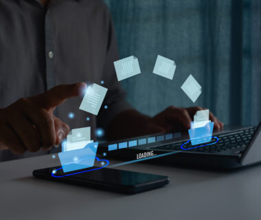 Transfer data document file folder to cloud using ai technology with online system for backup storage on mobile phone and laptop. Businessman hand touch on document for send of document on internet.