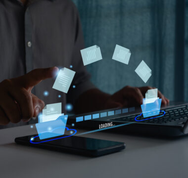 Transfer data document file folder to cloud using ai technology with online system for backup storage on mobile phone and laptop. Businessman hand touch on document for send of document on internet.